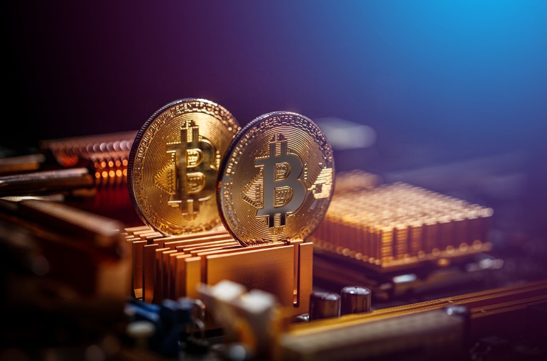 Bitcoin placed on a computer’s motherboard against a blurred background