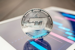 Dash In Silver Coinage Balanced On a Tablet Screen